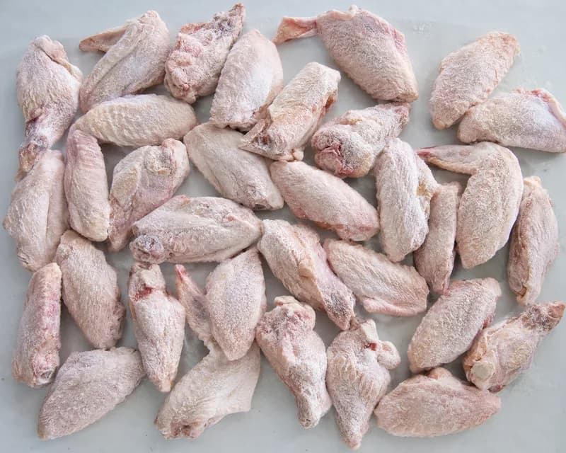 Raw frozen chicken wings spread in a single layer
