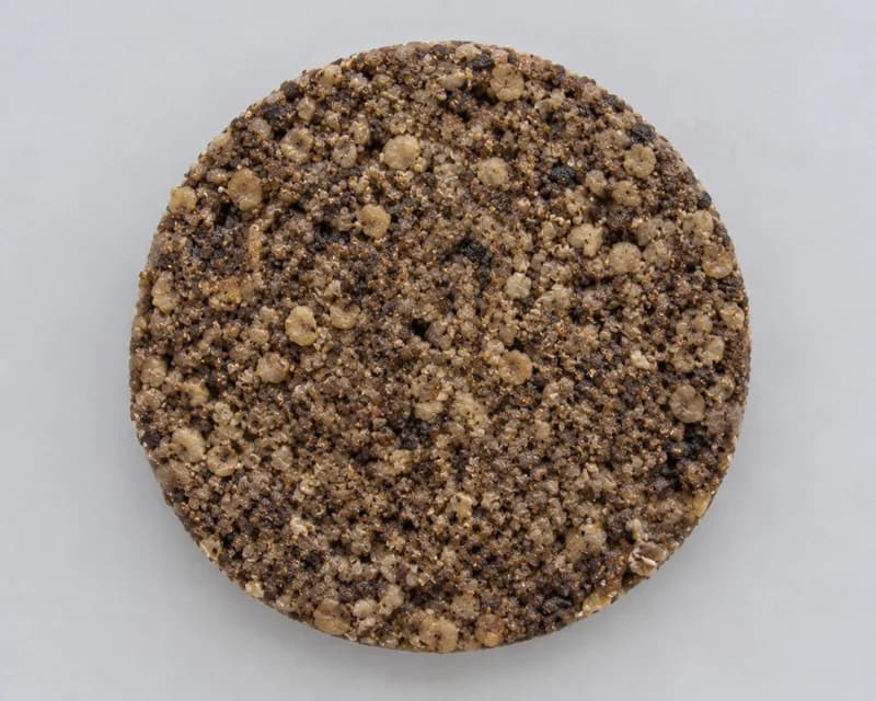 A slice of plant-based haggis showing a coarse oat and pulse filling